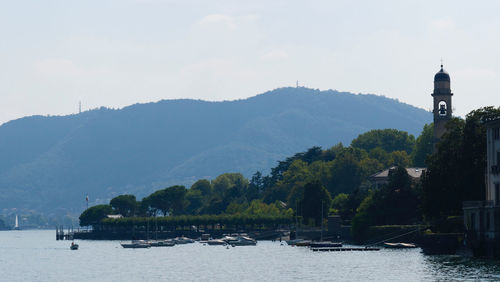 Scenic view of river by buildings against sky