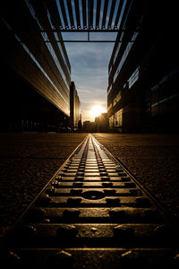 Railroad tracks in city against sky