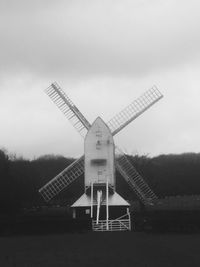 Traditional windmill on field against sky