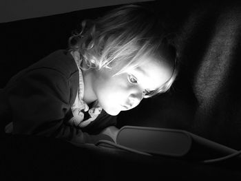 Close-up of girl sitting on sofa at home