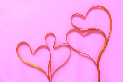 Close-up of heart shape against pink background
