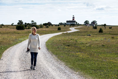 Woman walking on country road, gotland, sweden