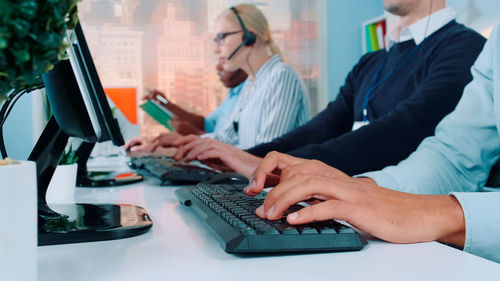 Midsection of business colleagues working on table