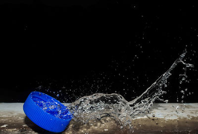 Close-up of water splashing against black background