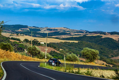 Road by landscape against sky