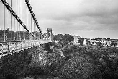 Bridge by buildings against sky