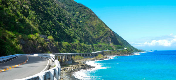 Panoramic shot of road by sea against sky