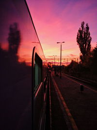 Train on railroad tracks against sky during sunset