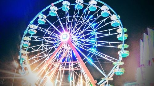 Low angle view of illuminated ferris wheel at night
