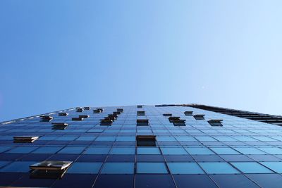 Low angle view of skyscraper against clear blue sky