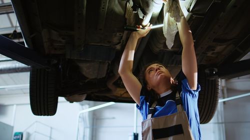 Rear view of young man standing in factory