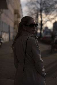 Portrait of young woman standing in city