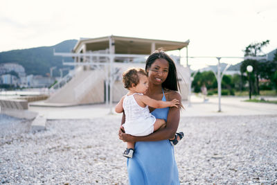 Happy mother with daughter standing outdoors