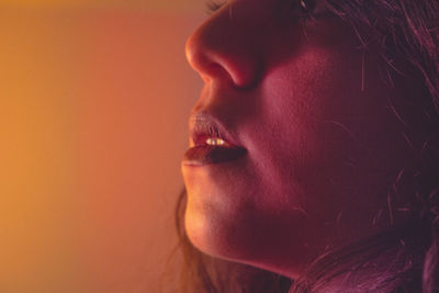 Close-up of young woman against wall