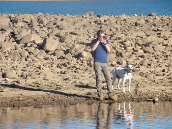 Full length of man standing at lakeshore