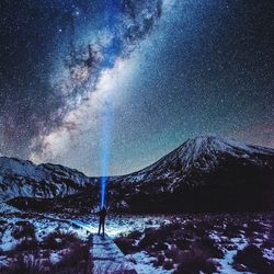 Scenic view of snowcapped mountains at night