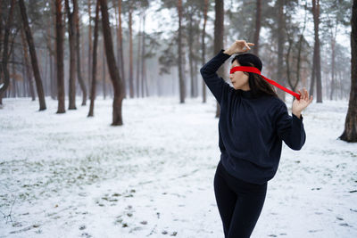 Shaman woman with tied eyes in mystical winter forest