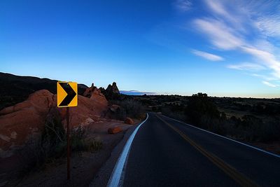 Road amidst landscape against clear blue sky