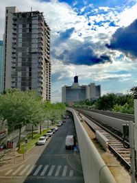 View of city street and buildings against sky