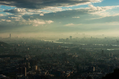 High angle view of cityscape against cloudy sky