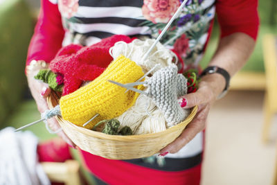 Midsection of senior woman holding knitting basket at nursing home