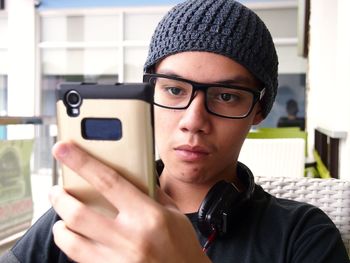 Close-up portrait of teenager using smart phone
