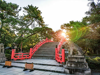 Footbridge at park against clear sky