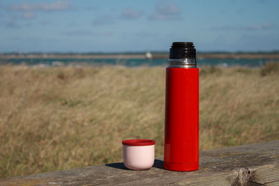 Close-up of thermos bottle on bench