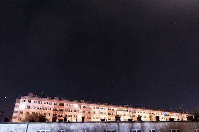 Low angle view of buildings against sky at night