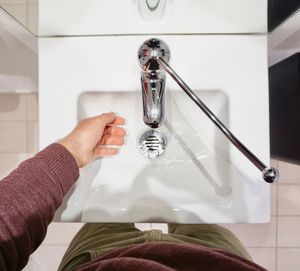 Close-up of woman hand holding faucet