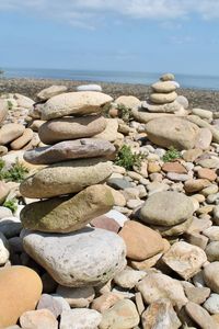 Stack of stones on beach against sky