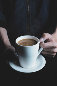 Close-up of hand holding coffee cup