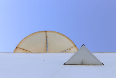 Close-up of clock against clear blue sky