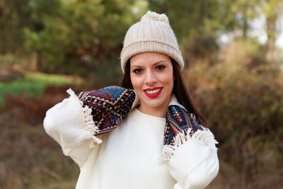 Portrait of smiling woman wearing knit hat in park