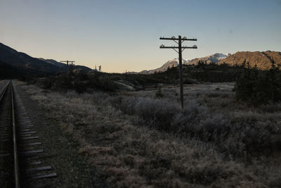 Railroad tracks on field against sky