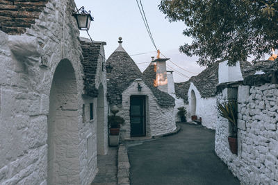 Footpath amidst buildings against sky