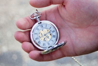 Close-up of hand holding clock