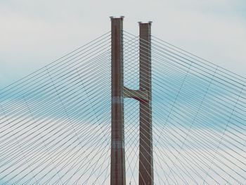 Low angle view of suspension bridge against sky