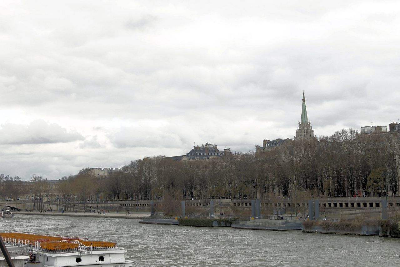 RIVER AMIDST BUILDINGS AGAINST SKY