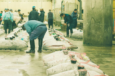 Rear view of people walking on wet street in city