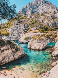 Scenic view of rocks by sea against sky