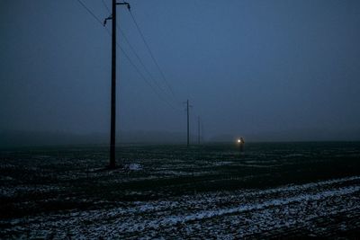 Electricity pylon on field against sky