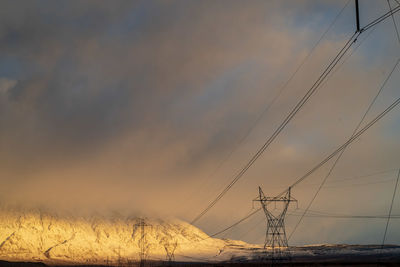 Electricity pylon against sky during sunset