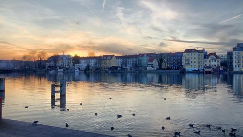 Sea and buildings in city against sky