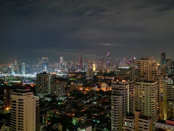 Illuminated modern buildings in city against sky