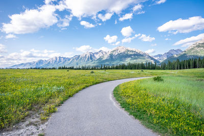 Road amidst field against sky