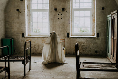 Little ghost standing in the abandoned house. autumn halloween