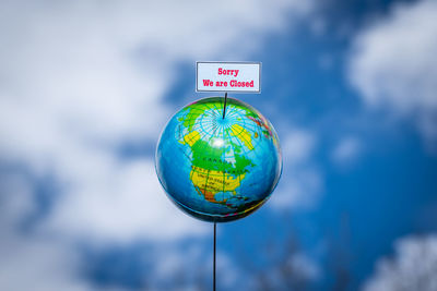 Close-up of information sign against blue sky