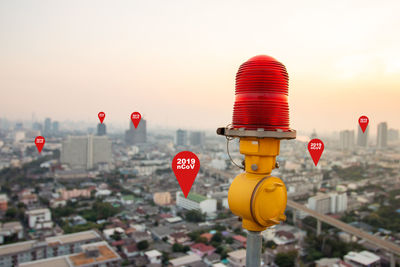 Red lanterns against buildings in city against sky