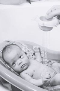 Close-up of baby having bath in bathroom